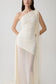 Woman wearing a white one-shoulder maxi dress.