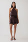 Woman wearing a brown satin halter ini dress. 