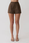 Woman wearing brown striped pintuck cotton shorts.