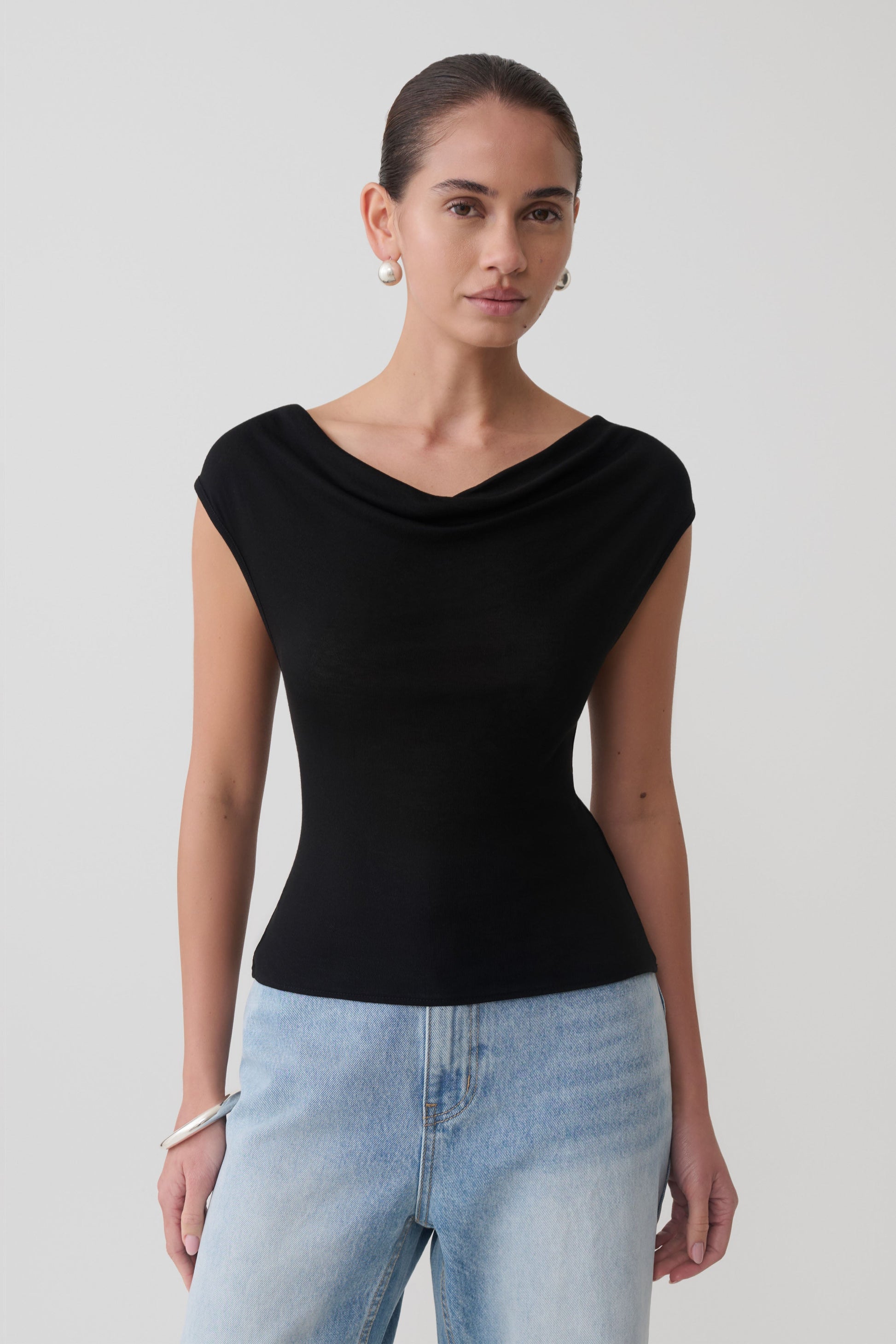 Woman wearing a black sleeveless sheer top.