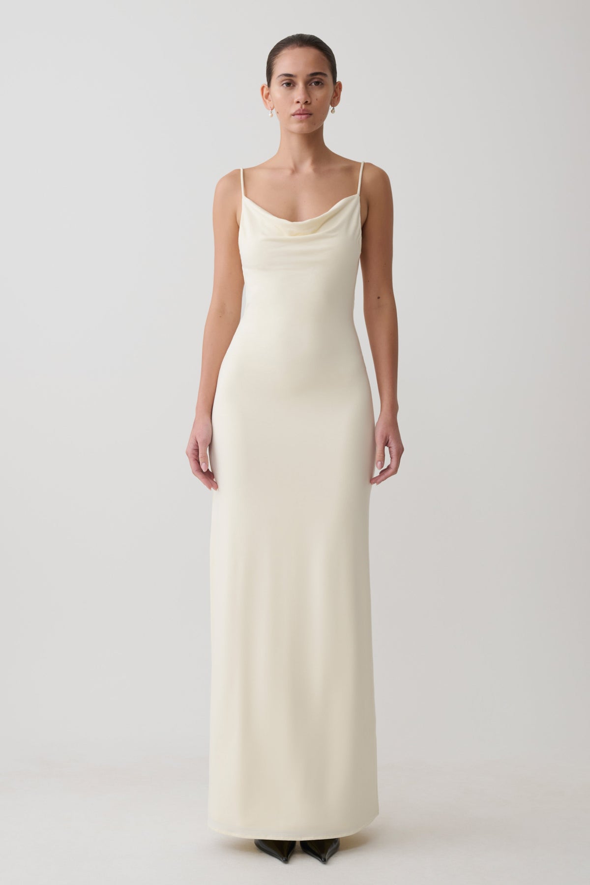 Woman wearing a white cowl maxi dress.