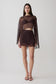 Woman wearing brown bralette with chiffon cape with matching lace and satin mini skirt.