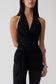 Woman wearing a black front tie halter top.