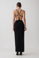 Woman wearing a crepe strapped back maxi dress with silver hardware.