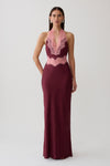 Woman wearing a burgundy satin and lace maxi dress.