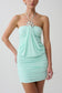 Woman wearing light blue halter with hardware mini dress.