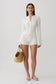 Woman wearing a white pointelle knit long sleeve top with matching shorts.