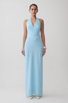 Woman wearing a light blue halter neck maxi dress.