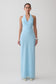 Woman wearing a light blue halter neck maxi dress.