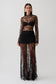 Woman wearing a black long sleeve lace maxi dress.