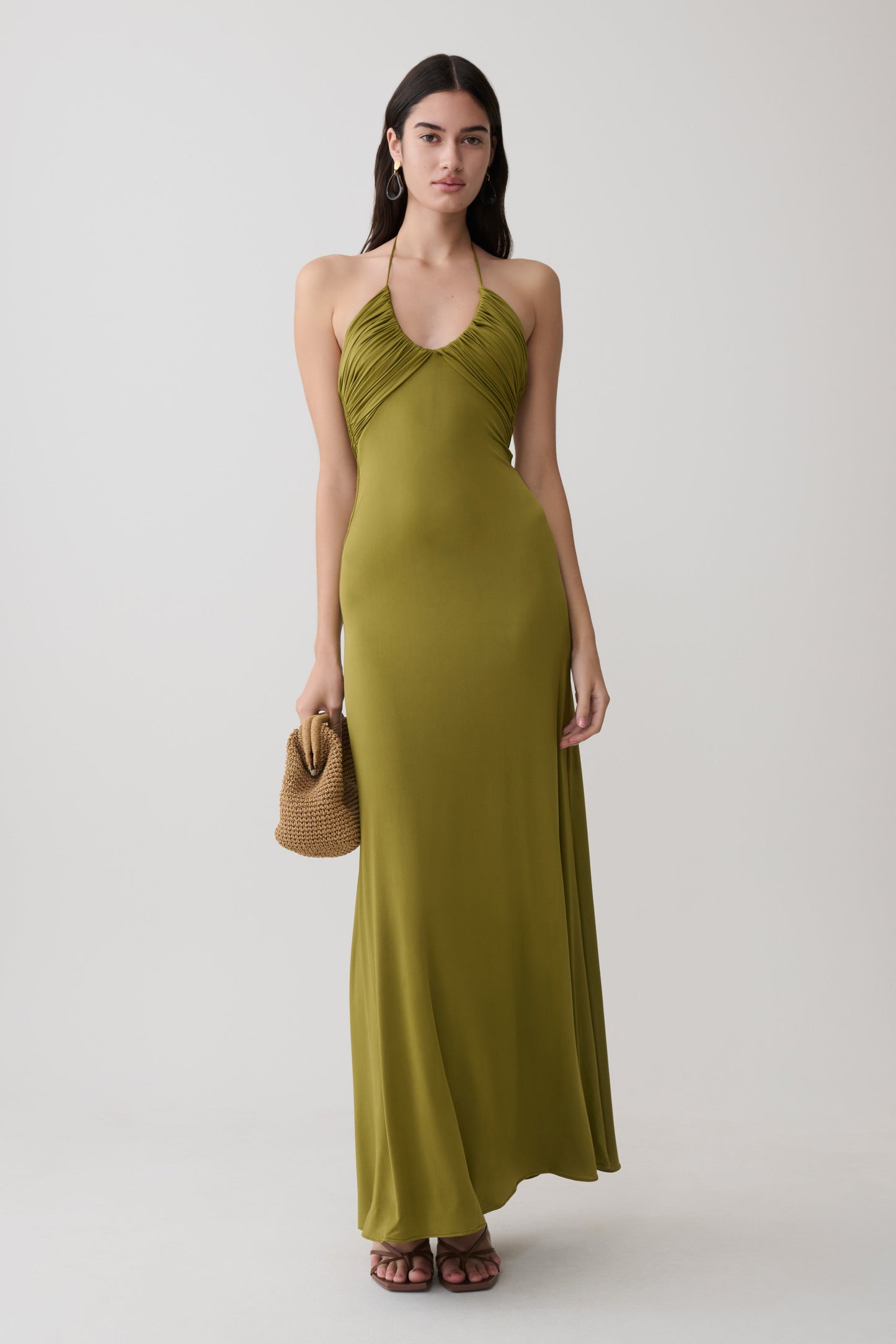 Woman wearing a green gathered slinky maxi dress.