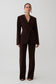 Woman wearing dark brown drop shoulder suiting blazer, with matching suiting pants.