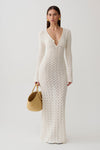 Woman wearing a white crochet knit maxi dress.