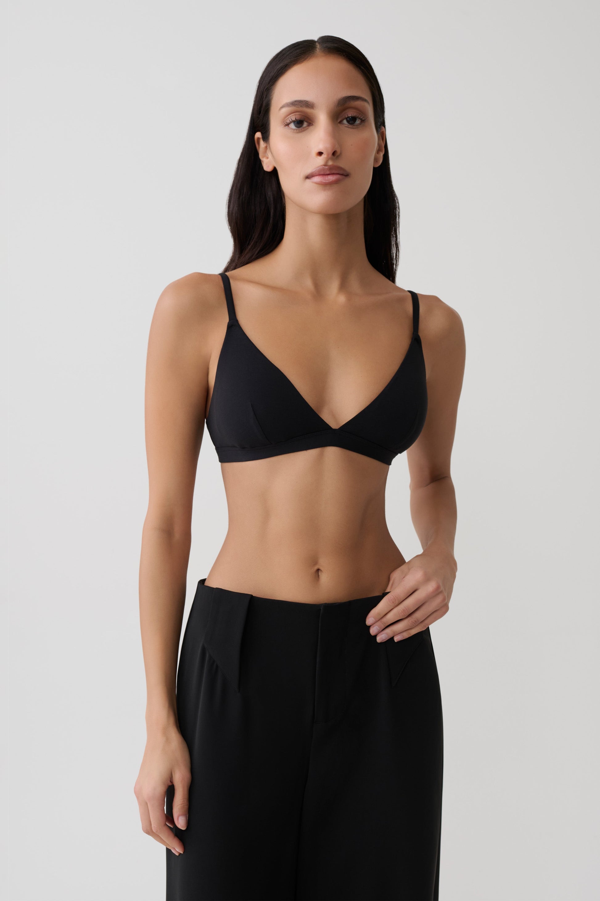 Woman wearing black micro triangle bralette.