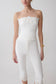 Woman wearing a white embroidery strapless denim top.