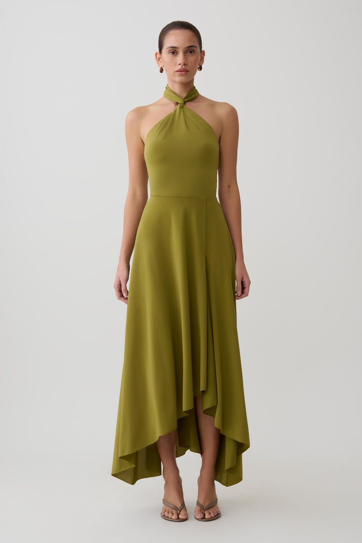 Woman wearing a green twisted neck dry jersey bodysuit with matching maxi skirt.