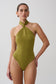 Woman wearing a green twisted neck dry jersey bodysuit.