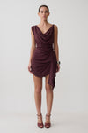 Woman wearing a dark purple cowl drape satin mini dress.