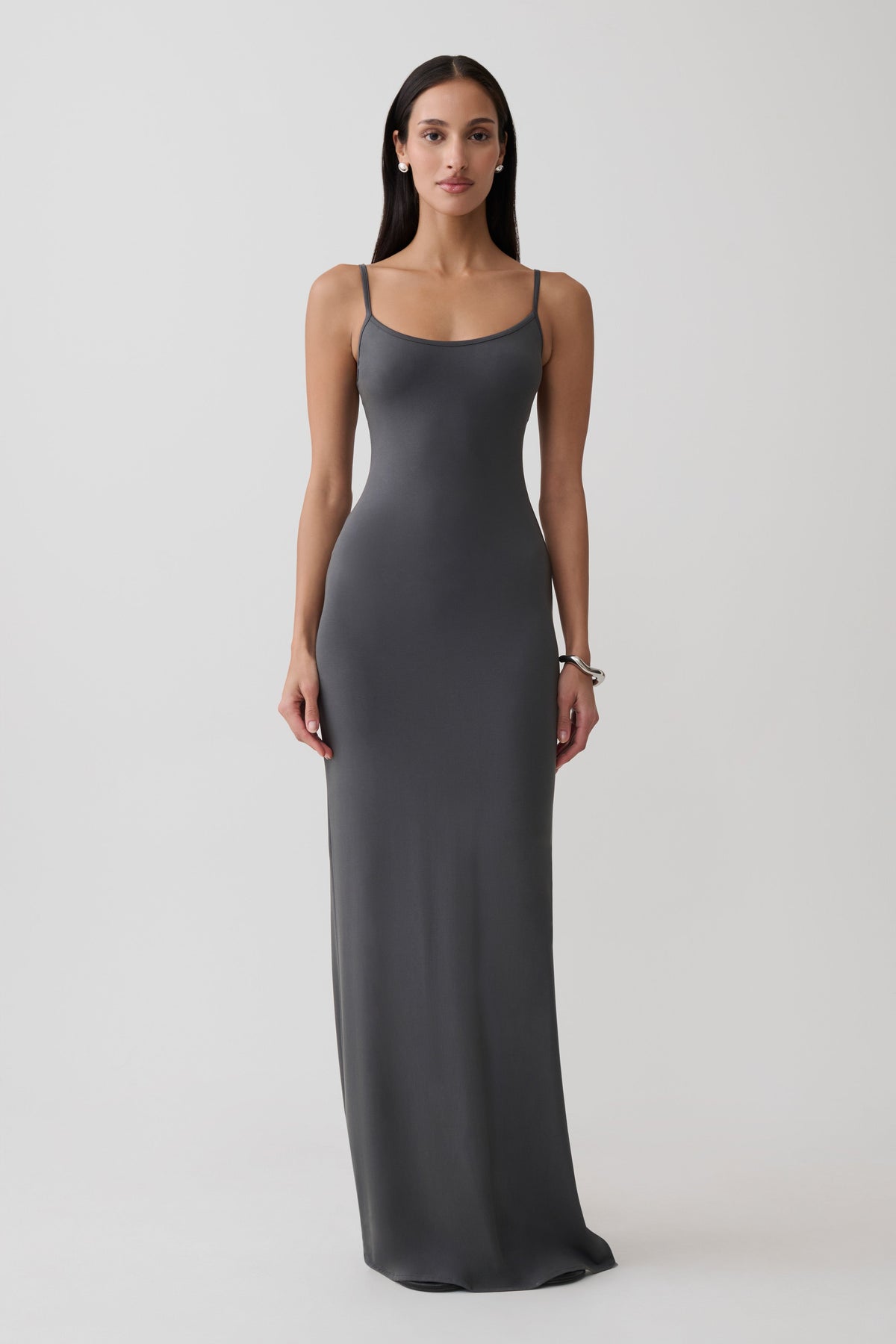 Woman wearing a grey peached jersey maxi dress.