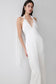 Woman wearing a white satin maxi dress with draped shoulders.