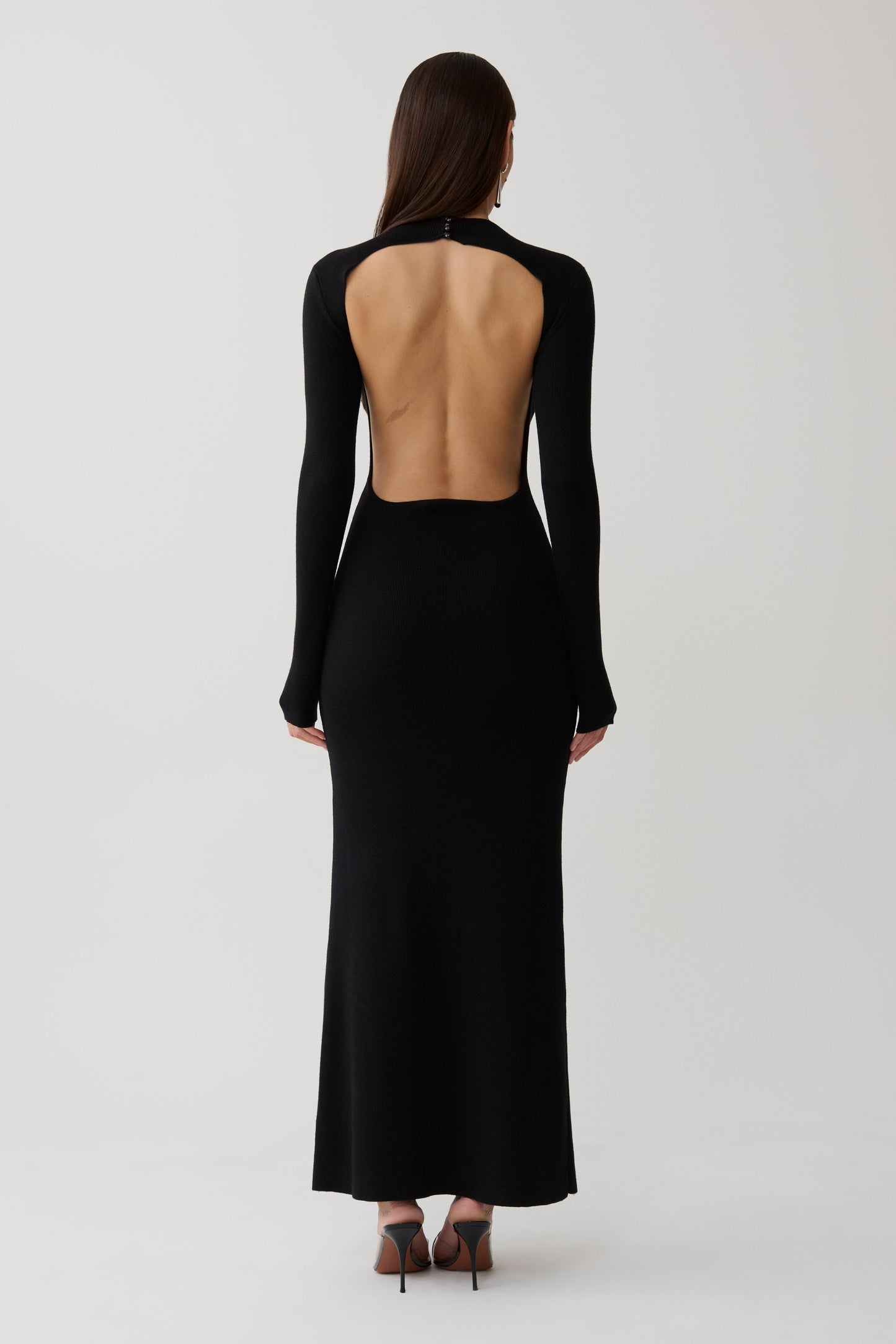 Woman wearing a black long sleeve knit maxi dress.