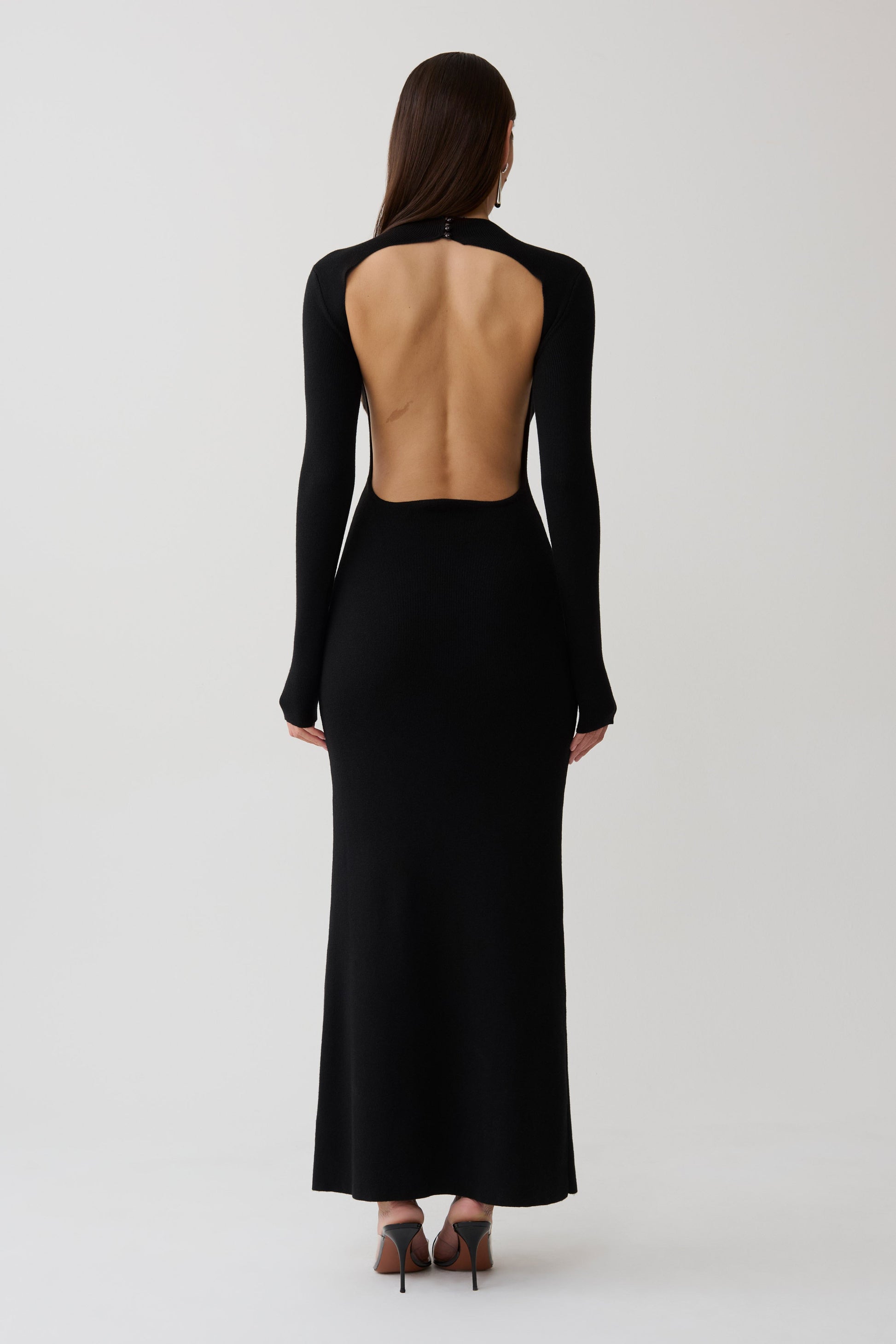 Woman wearing a black long sleeve knit maxi dress.