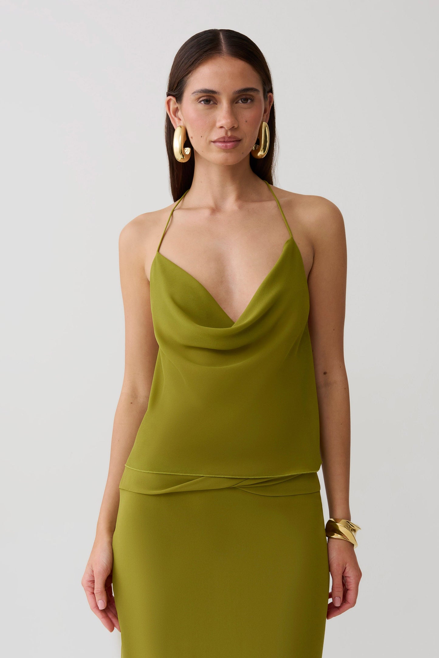 Woman wearing a green low back chiffon top.