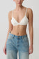 Woman wearing a white micro triangle bralette.