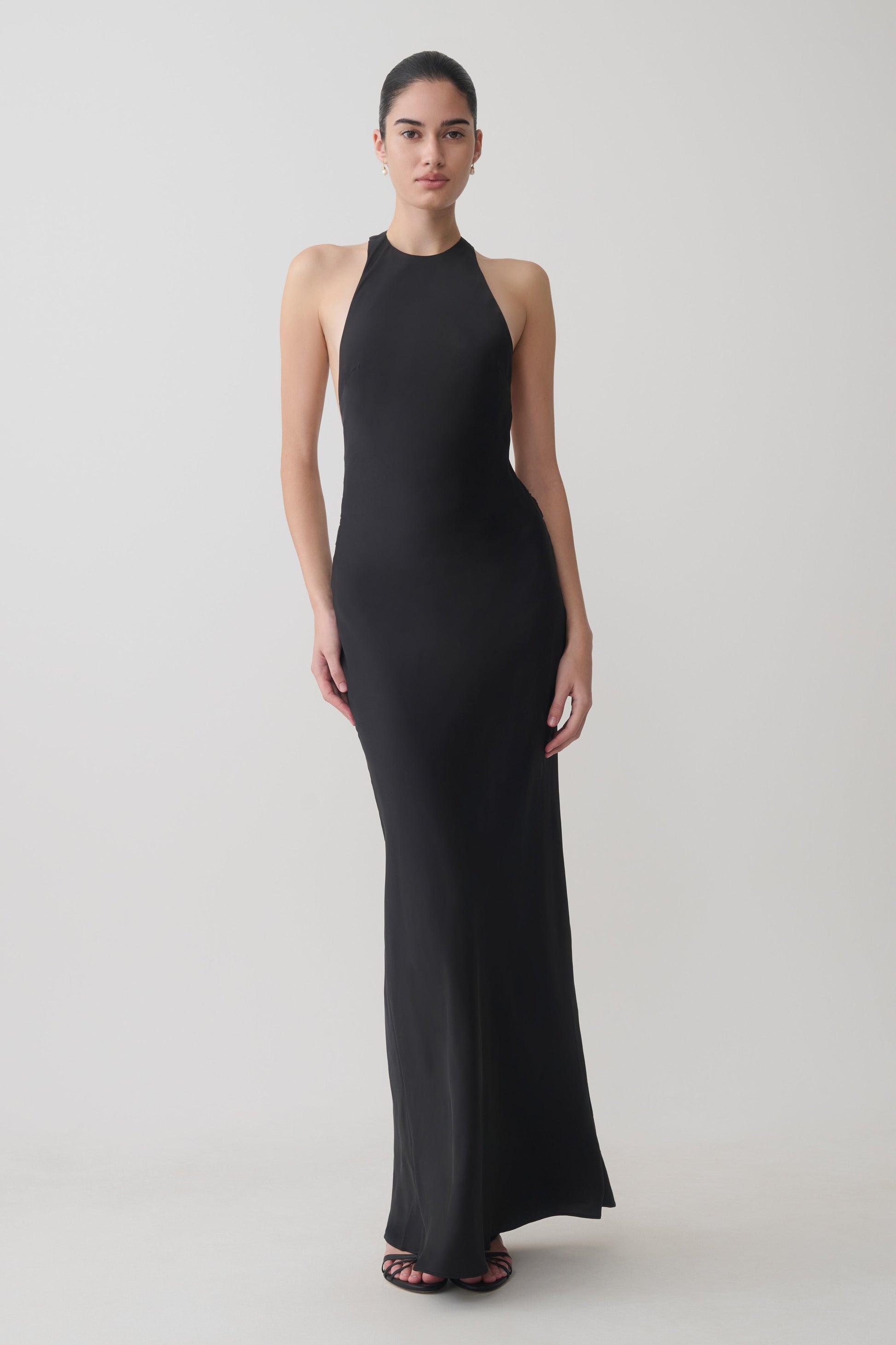 Woman wearing a black satin halter maxi dress.