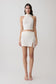Woman wearing a white halter backless knit top with matching skirt.