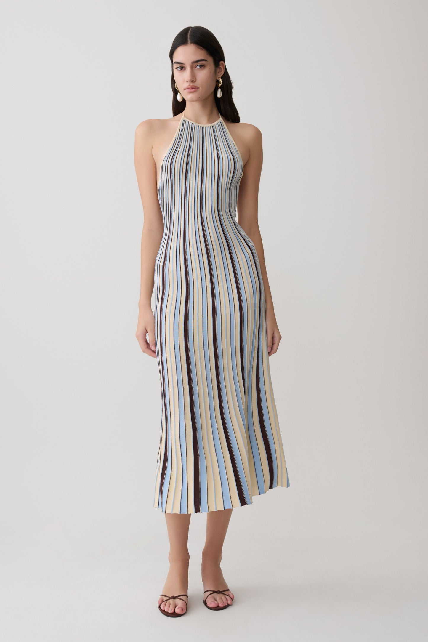 Woman wearing a striped blue and brown halter neck knit midi dress.