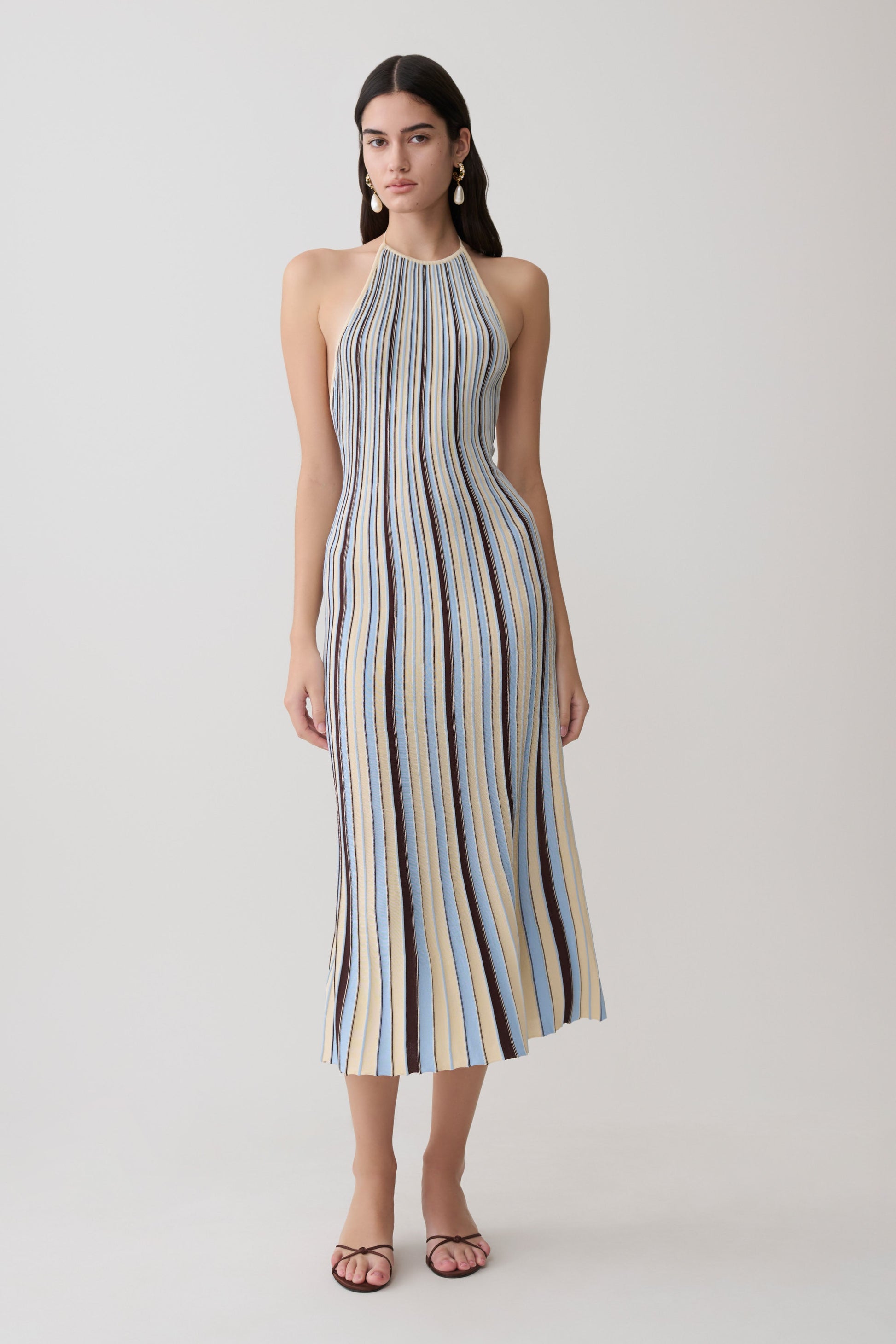 Woman wearing a striped blue and brown halter neck knit midi dress.