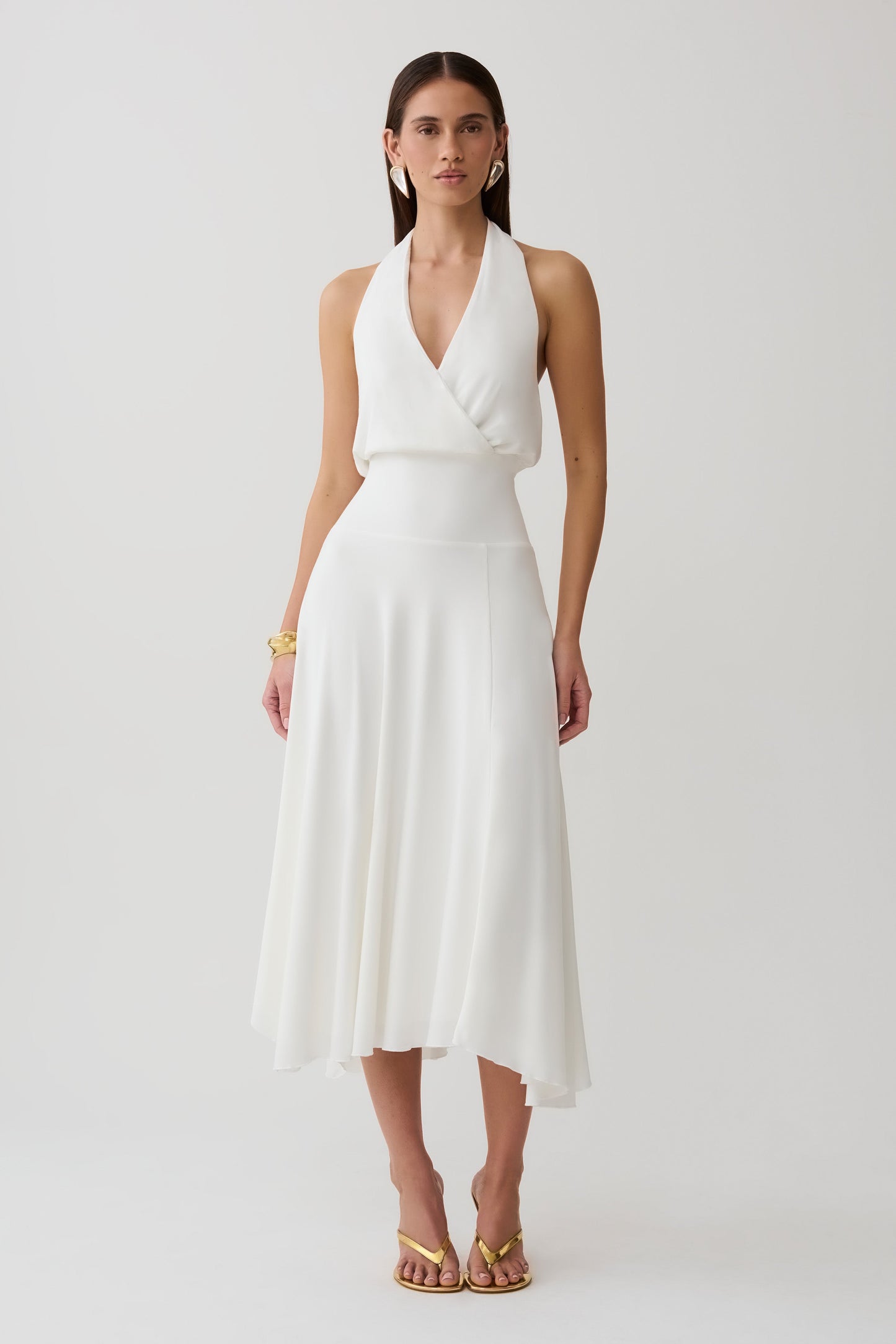 Woman wearing a white hankie halter midi dress.