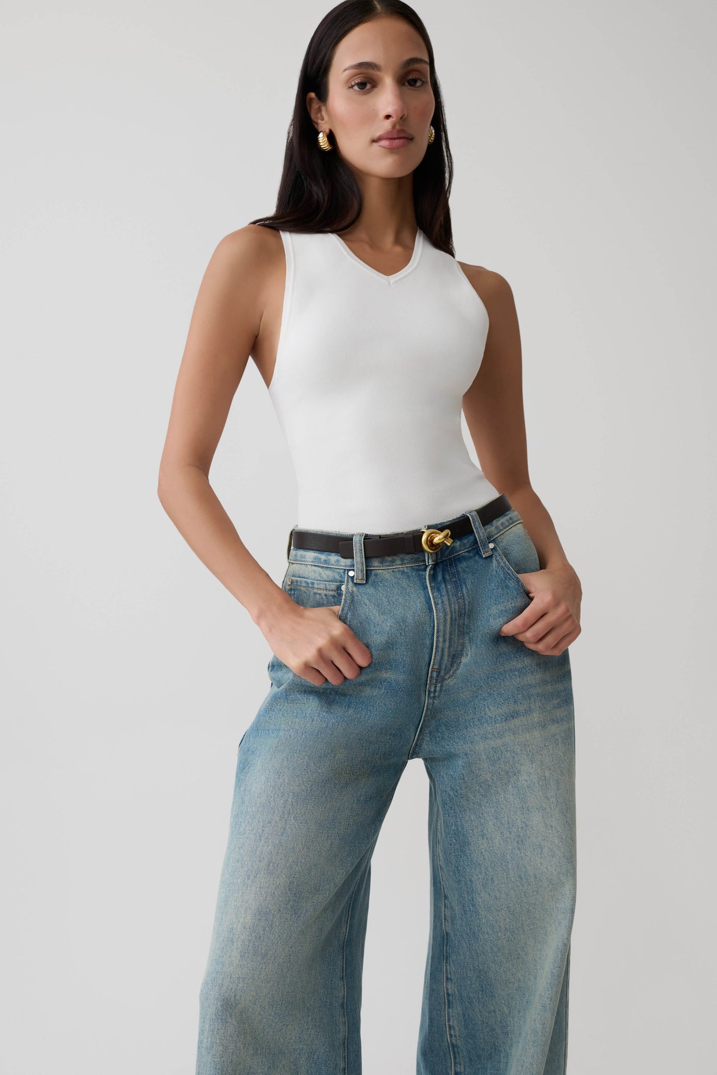 Woman wearing a knit white tank top.
