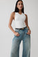Woman wearing a knit white tank top.