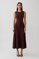 Woman wearing a brown pleated midi dress.
