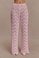 Woman wearing a pink crochet pants.