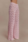 Woman wearing pink crochet pants.