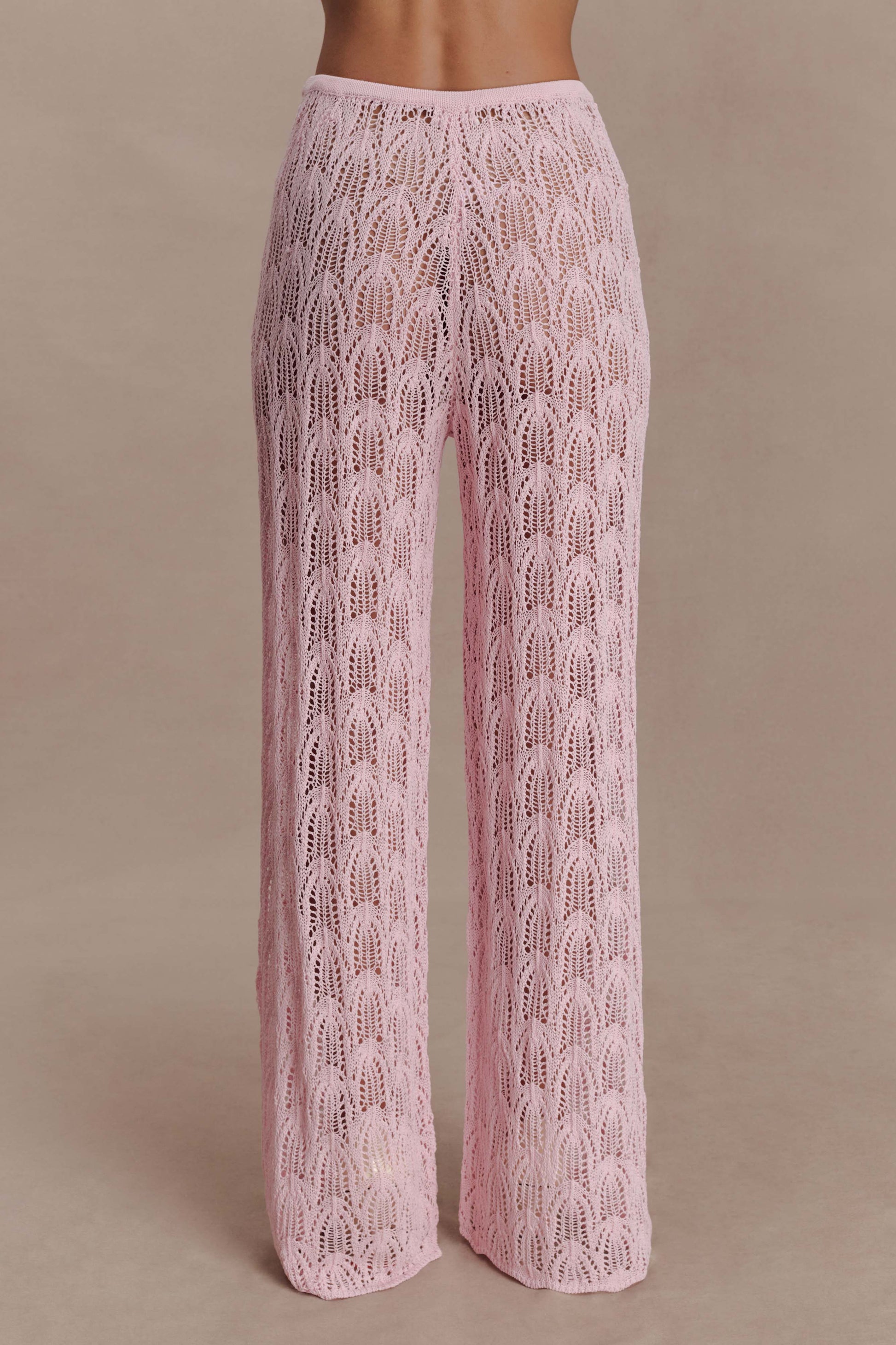 Woman wearing pink crochet pants.
