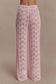 Woman wearing pink crochet pants.