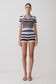 Woman wearing a striped outfit on a plain background.