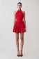Red halter dress worn by a model on a light gray background