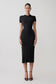 Woman wearing a black dress on a white background.