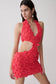 Woman wearing a red floral crochet mini dress.