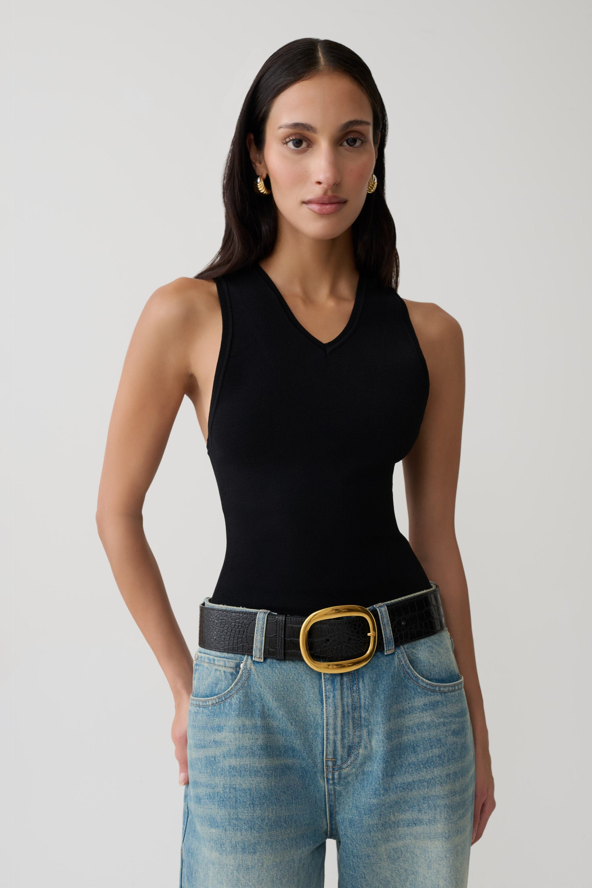 Woman wearing a black knit tank top.