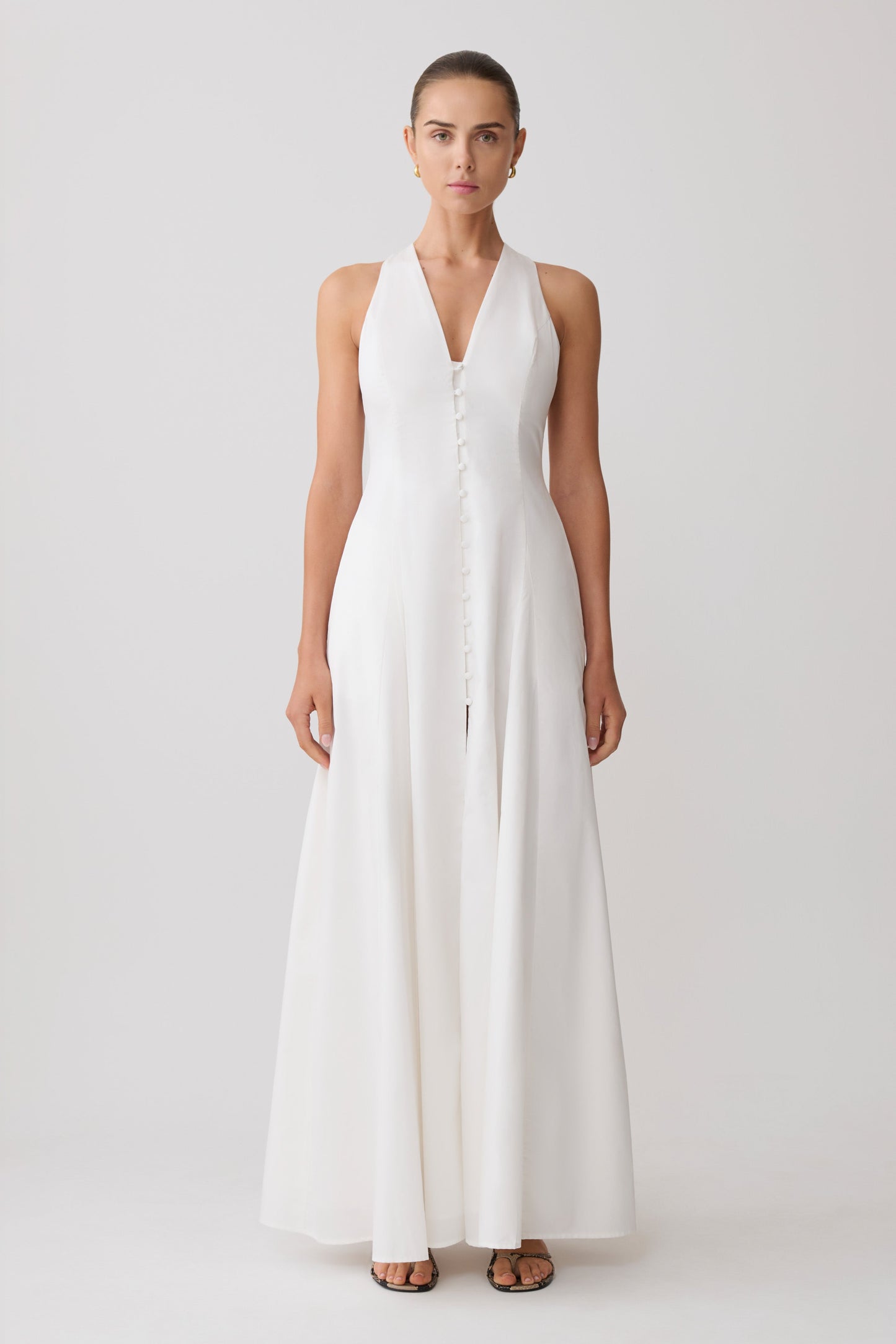 Woman wearing a white sleeveless maxi dress.