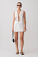 Woman wearing a white broderie tie top with matching mini skirt.