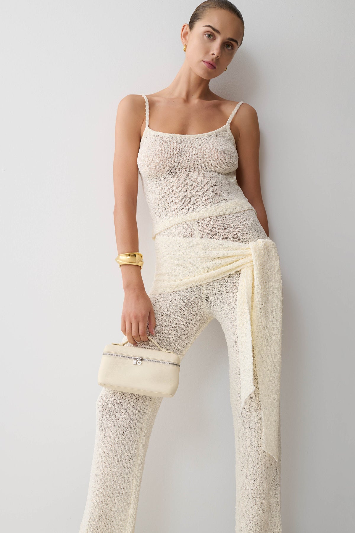Woman wearing white boucle knit top with matching tie pants.