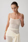 Woman wearing white boucle knit top.