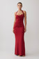 Woman wearing a gathered red halter neck maxi dress.